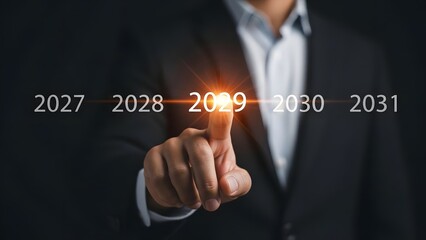 Obraz premium Businessman's hand points directly at the year 