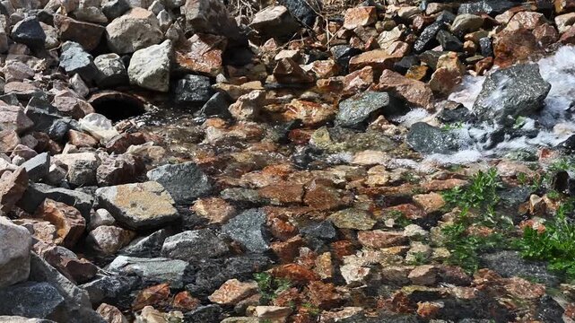 Construction site, treated water being pumped out of stormwater retention vault, across rocks and into stormwater system, industrial water filtration cleaning system 
