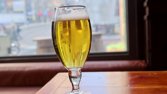 Golden beer resting on rustic table during soft daylight