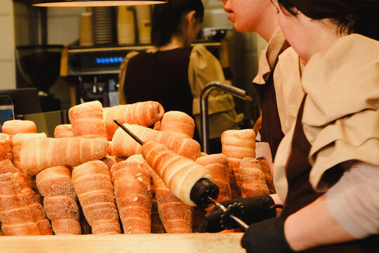 Trdelnik or trdlo on a stall, it's spit cake made from rolled dough  wrapped around a stall grilled and topped with sugar and walnut mix, chimney cake. Iconic street food from Prague, Czech Republic