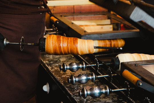 Trdelnik or trdlo on a stall, it's spit cake made from rolled dough  wrapped around a stall grilled and topped with sugar and walnut mix, chimney cake. Iconic street food from Prague, Czech Republic