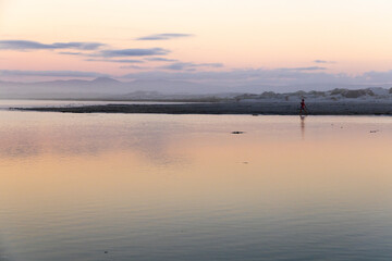 Fototapeta premium young boy playing at lagoon edge, Hermanus, South Africa