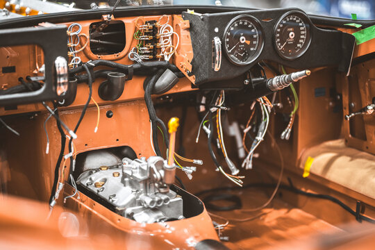 Vintage car dashboard undergoing restoration with exposed wiring and engine components