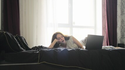 Obraz premium Young woman working from home on a laptop but fell asleep