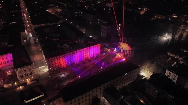 New Years Eve 2026 in Munich featuring a futuristic light show at the Triumphal Arch. Crowds gather at Ludwigstrasse for a midnight countdown and projection mapping display.