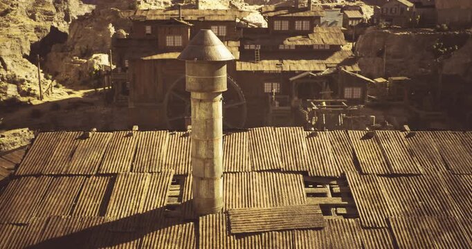 This location features a rustic mining settlement characterized by its old wooden structures and towering machinery amidst a rugged desert backdrop, showcasing its historical significance.