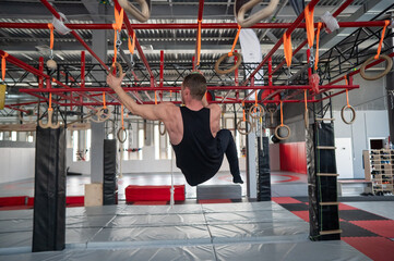 An athletic man practices at a ninja club's indoor obstacle course. © Михаил Решетников
