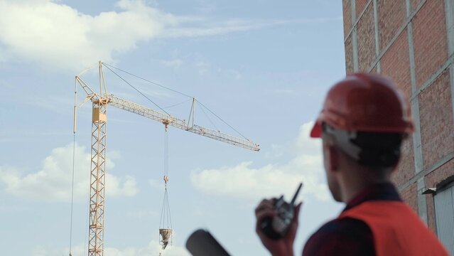 Construction superintendent coordinating site works over two-way radio