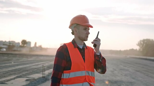 Professional builder talking with worker via radio set