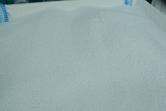 Virgin polyethylene terephthalate or PET granules in box. Granulated plastic polymer