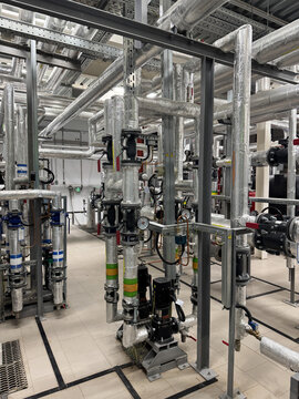 Industrial heating system and pumping station. Piping system with foil insulation, vapor barrier. Pipes equipped various instruments, including pressure gauges, temperature sensors, and flow meters