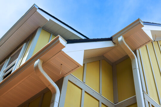 Roof details gutters on yellow house under construction site.