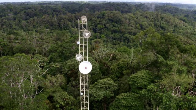 Puyo, Ecuador, 18-12-2021: Aerial view, turning around a parabolic dish or satellite dish placed on an antenna located in the forest