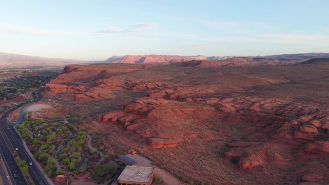 Aerial sunrise over red rock cliffs and mountains in St George, Utah