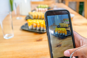 Person capturing peruvian japanese fusion maki sushi © Guillermo Spelucin