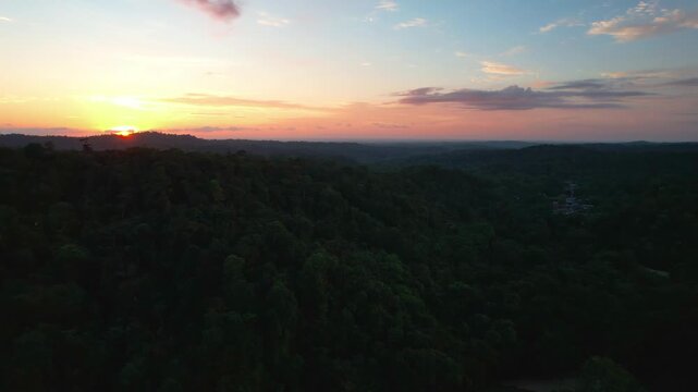 Golden sunset aerial view over rolling hills forest