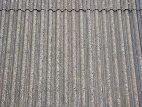 Corrugated fiber cement sheets for industrial warehouse roofing and cladding, uralita roof maintenance and safety. Weather protection, facility management, structural integrity, renovation projects.
