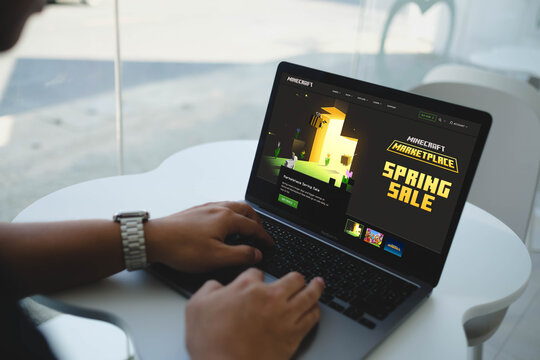 Bangkok, Thailand. April 13, 2026; A person types on a laptop displaying the Minecraft Marketplace Spring Sale page while sitting in a bright indoor workspace.