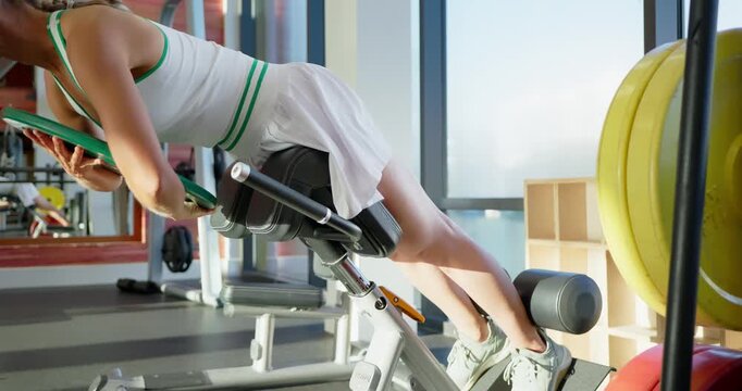 Woman Performing Back Extension Exercise in Gym