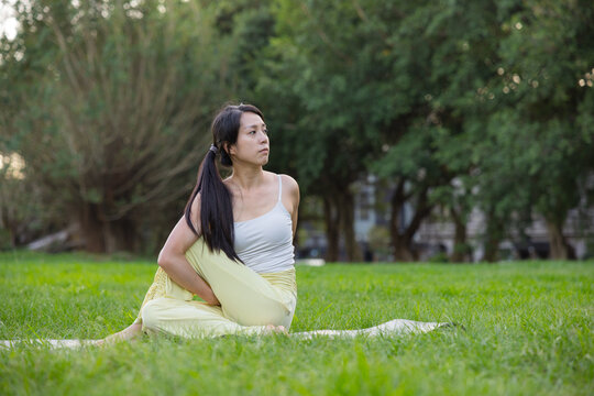 Woman doing yoga practice outdoors in park