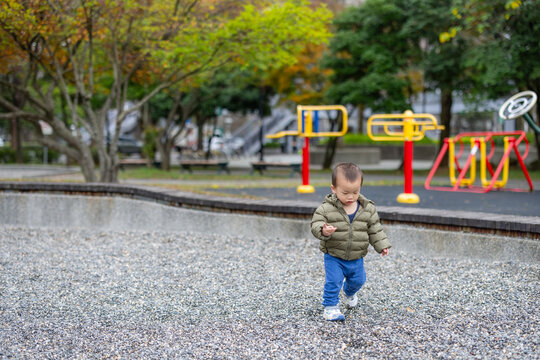 Little boy running happily in green park