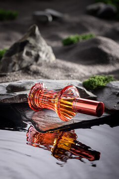 Sophisticated red perfume illuminated by moonlight on black water.