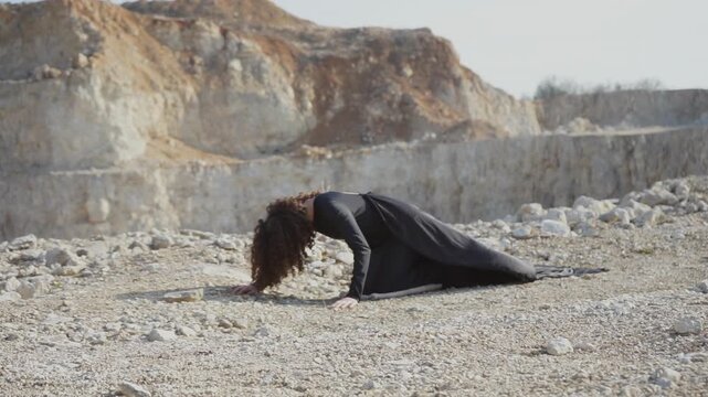 Desperate woman crawling in a dry, rocky desert