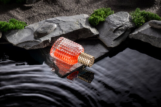 Aromatic red perfume in a lunar landscape with water.