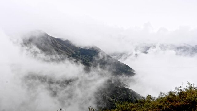 Dramatic Mountain Peak Emerging Through Swirling Clouds and Fog China 4K