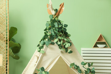 Cute wigwam with leaves in stylish child's room © New Africa