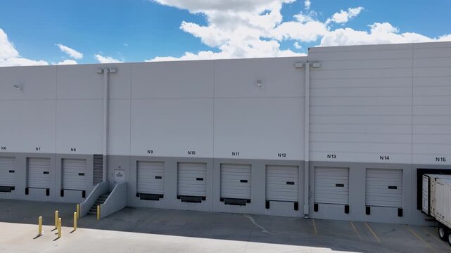 Drone Orbit Shot Right to Left of Commercial Warehouse Loading Dock with Shipping Container