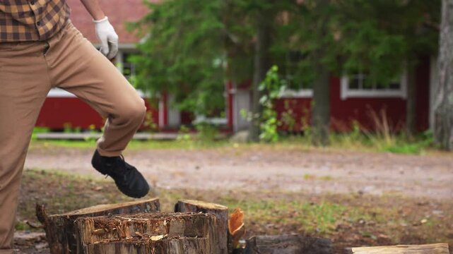Close up of chopping a wooden log with an axe in slow motion. Professional 4K ProRes 422 footage of manual firewood preparation.