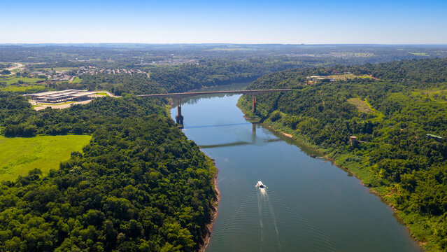 Aerial view of Tancredo Neves Bridge over Iguazu River with boat crossing border.