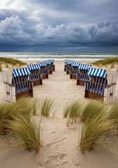 Fototapeta premium Beach chairs on sandy dune. Coastal landscape with overcast sky, ocean waves. Northern sea vacation, stormy weather concept.