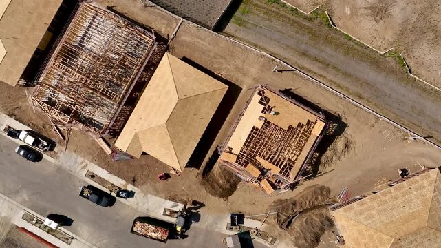 Aerial Vertical Descent Shot of a Busy Residential Housing Construction Site with Building Development Activity.
