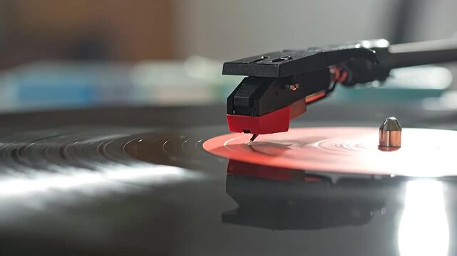 A close-up view of a record player needle on a spinning, vintage vinyl record disc