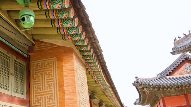 Brightly colored eaves and decorative roof features against light sky