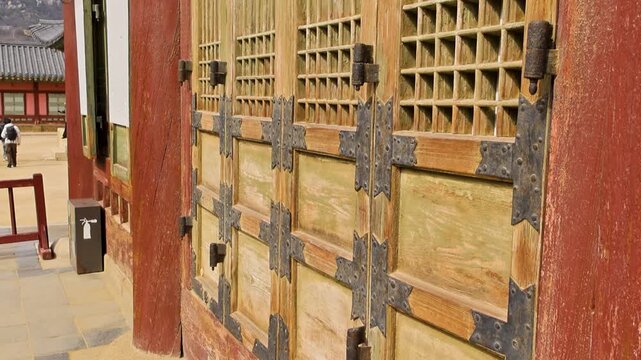 Historic wooden gate featuring intricate lattice and aged finish