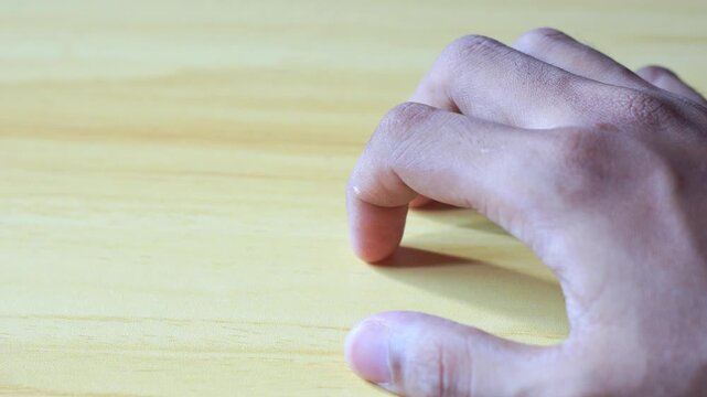 Muted photography of a hand resting on a wood surface, suitable for nature themed content, mindfulness, and natural beauty concepts.