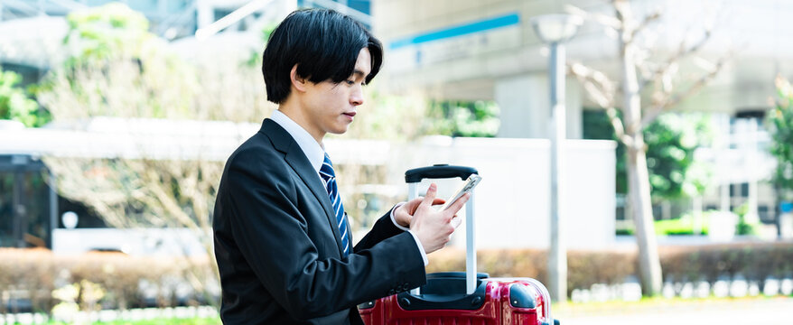 携帯を見る若い日本人男性