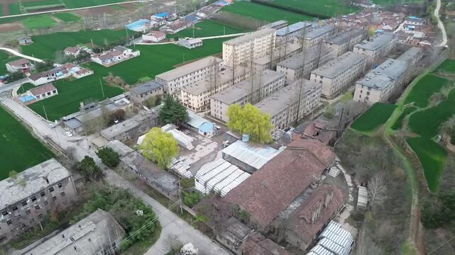 YANAN, CHINA - APRIL 12, 2026: An aerial drone perspective of rural residential houses nestled among lush green terraced fields on the Loess Plateau in northern Shaanxi province.