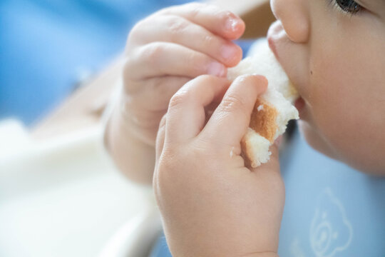 パンを食べる幼児のクローズアップ（手づかみ食べ・日常の食事風景）