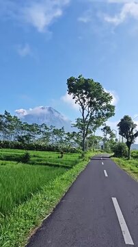Straight Road Leading to Mount Merapi Under Blue Sky