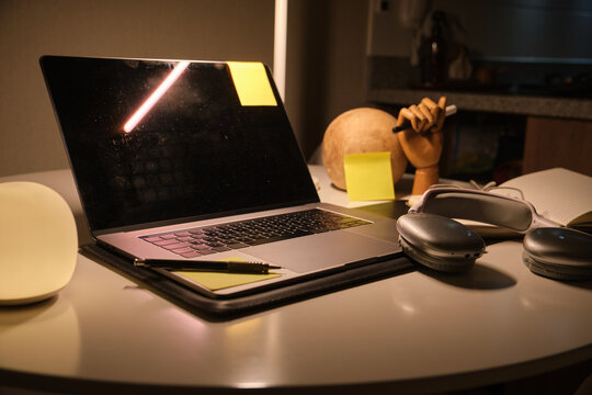 Desk with laptop, headphones, and lamp providing ambient light for work