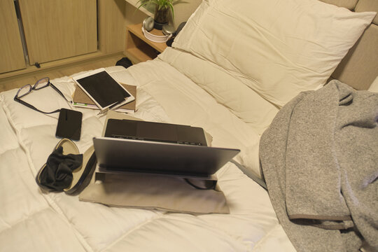 Digital devices creating a study and work area on a comfortable bed