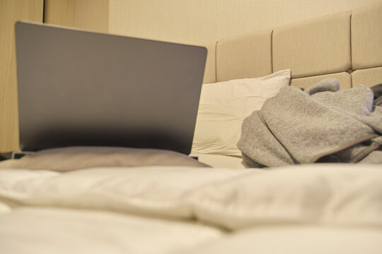 Laptop on bed in a home bedroom creating a comfortable remote workspace