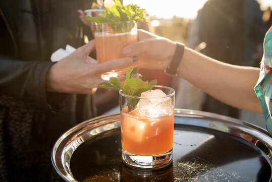Pink Cocktails Being Passed at an Outdoor Party 