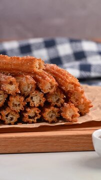 Close-up view of a stack of homemade churros cut in half and served with cajeta sauce