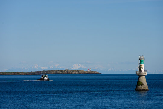 Brotchie Ledge Light, aid to navigation, ATON, small automated lighthouse in channel to Victoria harbor, tugboat heading out past Trial Islands Lighthouse in background
