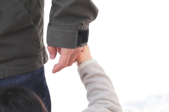 親と子どもが手をつなぐシーン（家族・愛情・子育て）